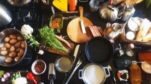 a kitchen counter with various cooking utensils and vegetables